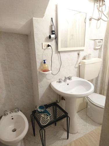 een witte badkamer met een wastafel en een toilet bij appartamento centro storico in Castelvetrano Selinunte