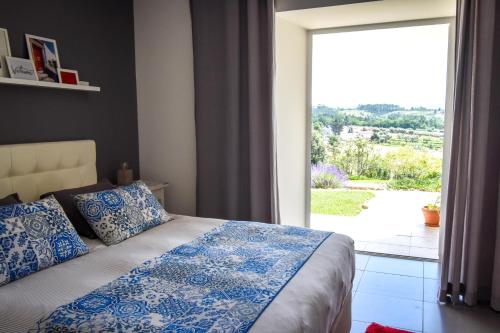 a bedroom with a bed and a large window at Casa nas Serras in Vila Nova de Poiares