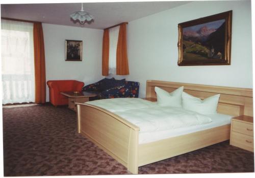 a bedroom with a bed and a chair in it at Hotel Gasthof Turm in Grünhaid