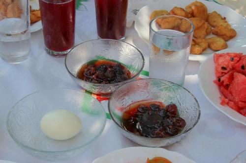 a table with bowls of food and plates of watermelon at Guri Guesthouse in Gjirokastër