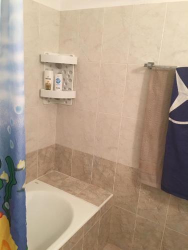 een badkamer met een bad en een douchegordijn bij By the sea in Paphos City