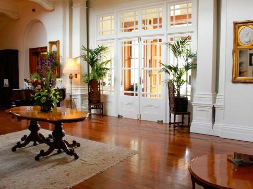 a living room with a table and a room with chairs at Tinakilly Country House Hotel in Rathnew
