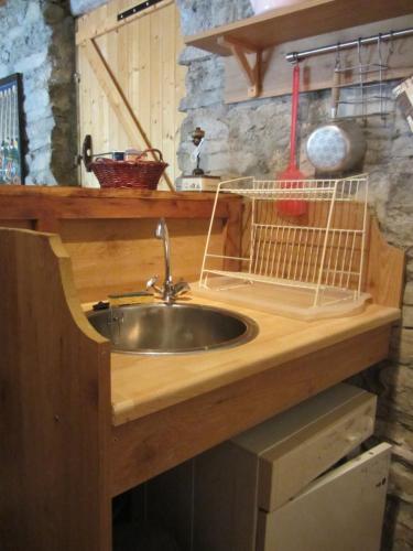 eine Küchentheke mit einer Spüle und einem Vogelkäfig in der Unterkunft Les Bruns in Les Thuiles