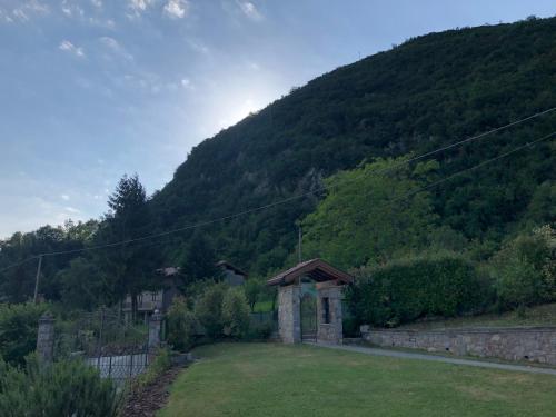 a small building in a field with a mountain at Alla Vecchia Contrada B&B in Provaglio Val Sabbia