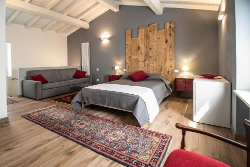 a bedroom with a bed and a couch at Bossema Luxury Countryhouse in Cavaion Veronese