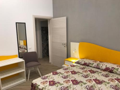 a bedroom with a bed and a desk and a mirror at LA DIMORA SICILIANA APPARTAMENTI in Trapani