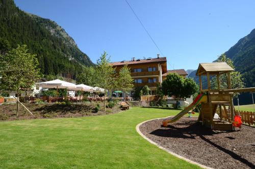 un parque infantil con un tobogán y un edificio al fondo en Alp Larain B&B, en Ischgl