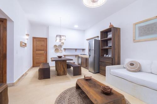 a living room with a white couch and a kitchen at CasaLô Hotel in Jericoacoara