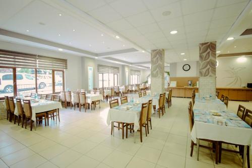 Basaranlar Thermal Otel في غازليغول: غرفة طعام مع طاولات وكراسي في مطعم