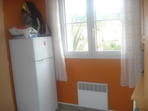 - un réfrigérateur blanc dans une cuisine avec fenêtre dans l'établissement LOCATION DE VACANCES, à Cerbère