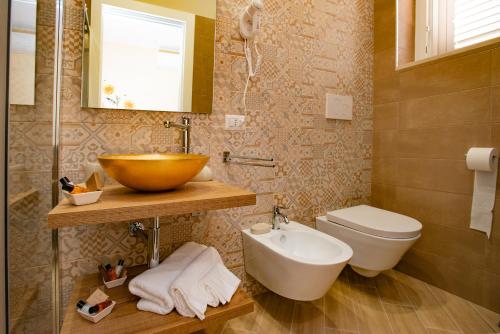 a bathroom with a bowl sink and a toilet at b&b Rita, nel cuore del Salento in Cavallino di Lecce