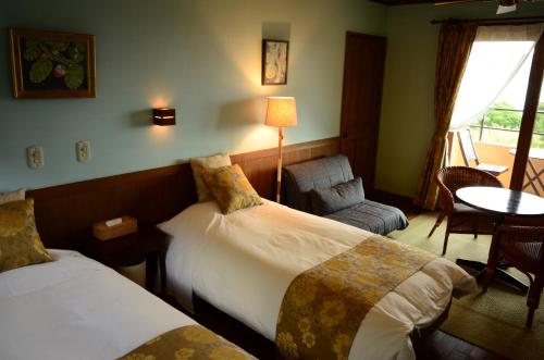 a hotel room with two beds and a chair at Villa Yurimun in Tatsugo