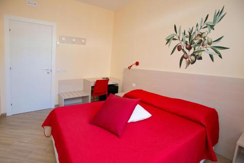 a bedroom with a red bed with a red blanket at b&b Rita, nel cuore del Salento in Cavallino di Lecce
