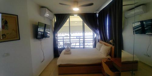 a small bedroom with a bed and a window at Dizengoff Penthouse Boutique Hostel in Tel Aviv