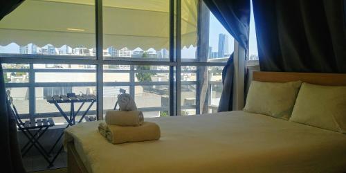 um quarto com uma cama e uma grande janela em Dizengoff Penthouse Boutique Hostel em Tel Aviv