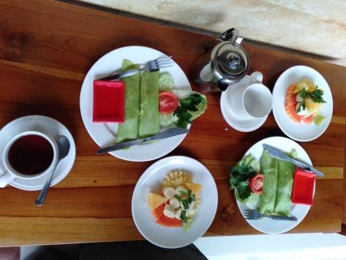 ウブドにあるHendra Houseの食べ物の皿とコーヒーカップが置かれたテーブル
