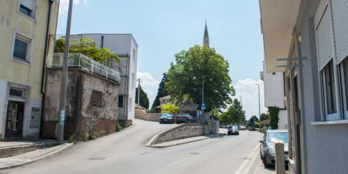 an empty city street with cars parked on the road at COMFORT APARTMENTS M&S in Mostar