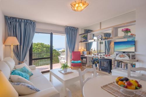 sala de estar con sofá blanco y chimenea en Beach Apartment Las Acacias Torrenueva, en La Cala de Mijas