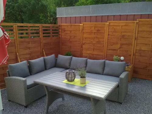 a patio with a couch and a table and a fence at Pension Appartementhaus Bergland in Biberwier