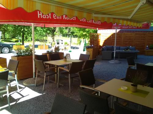 a restaurant with tables and chairs under a tent at Pension Appartementhaus Bergland in Biberwier