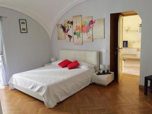 een slaapkamer met een wit bed en 2 rode kussens bij Gstar Flat in Piano di Sorrento