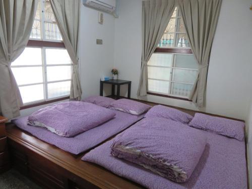 - une chambre avec 2 lits et des couvertures pourpres dans l'établissement Hoin 4, à Xigang