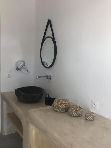 a bathroom with a sink and a mirror on the wall at Irida Vacation suites in Kastraki Naxou