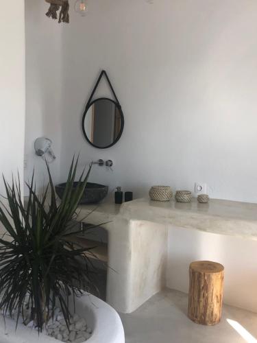 a bathroom with a table and a mirror and a plant at Irida Vacation suites in Kastraki Naxou