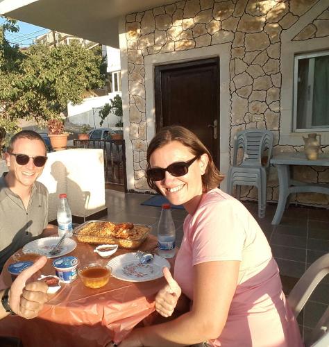 a man and a woman sitting at a table eating food at Mhna guest house in Ajloun