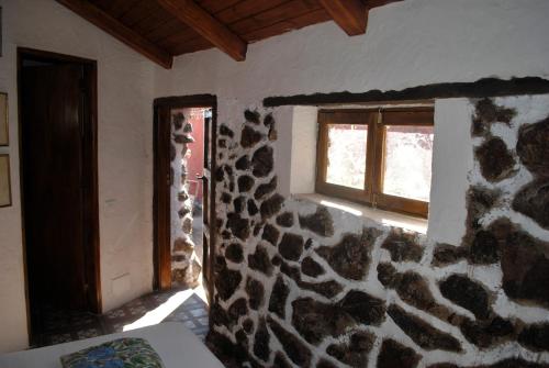 a room with a stone wall and a window at I MITI ViviendaVacacional in Chio