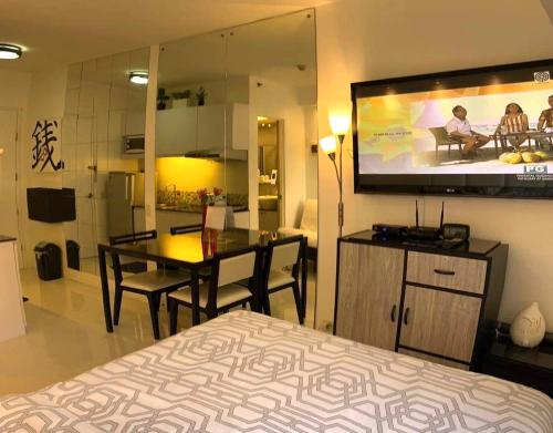 a bedroom with a bed and a television on the wall at Avida Condo near NAIA in Manila