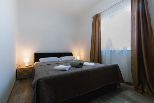 a bedroom with a bed and a large window at Putnik in Dugi Rat