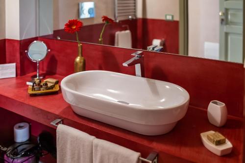 a white sink on a red counter in a bathroom at Cantine De Gregorio Suites in Sciacca