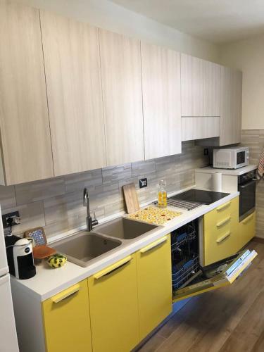 a kitchen with yellow cabinets and a sink at Daniele Guest Apartment in Pistoia
