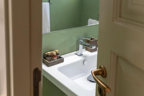 a bathroom with a sink and a mirror at Cantine De Gregorio Suites in Sciacca
