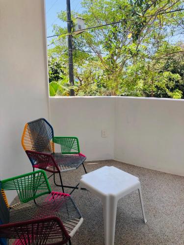a room with three chairs and a table and a window at Mar y Sueños Suites in Sayulita
