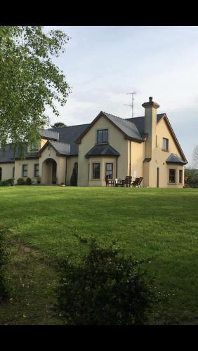 a large house with a large yard with green grass at Corness House B&B in Monaghan