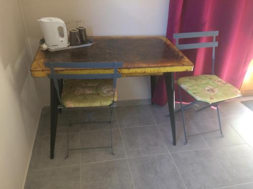 a wooden table with a chair next to a table at Les deux chemins in Mons