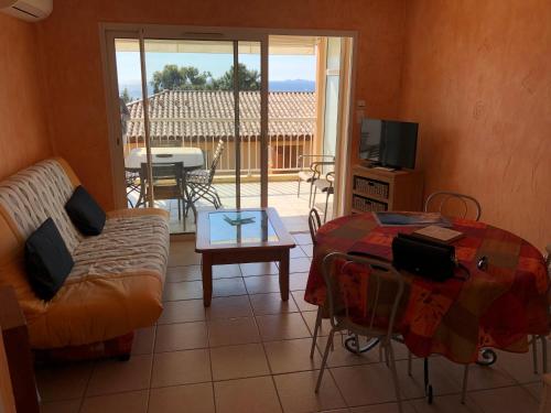 un salon avec un canapé et une table dans l'établissement PORTICCIO, AGOSTA PLAGE vue mer pour 6 p, 2 ch, PROMO 7 nuits, à Porticcio