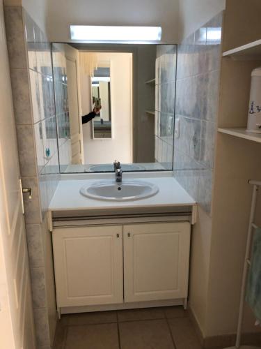 une personne prenant une photo d'un lavabo dans la salle de bains dans l'établissement PORTICCIO, AGOSTA PLAGE vue mer pour 6 p, 2 ch, PROMO 7 nuits, à Porticcio