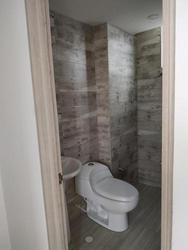 a bathroom with a toilet and a sink at Apartamento en Reserva del Peñon Girardot. in Girardot