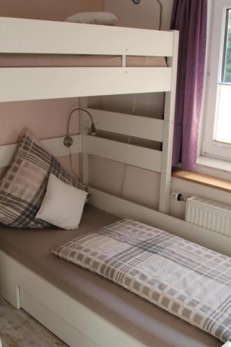 ニデッケンにあるPanoramablickの二段ベッド、枕、窓が備わる客室です。