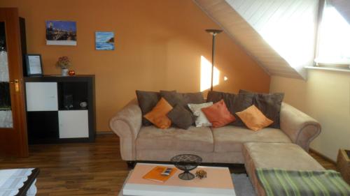 uma sala de estar com um sofá com almofadas em Ferienwohnung Tina em Pirna