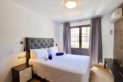 sypialnia z dużym białym łóżkiem i oknem w obiekcie APARTMENT GOLDEN costa teguise w Costa Teguise