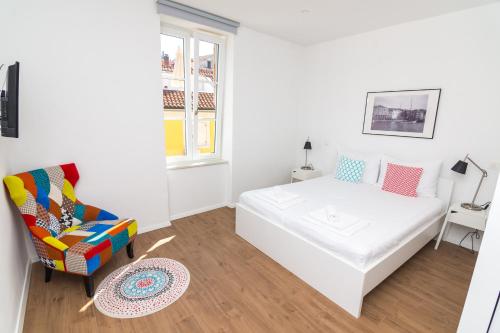 a white bedroom with a bed and a chair at Apartments and Rooms Jospino in Mali Lošinj