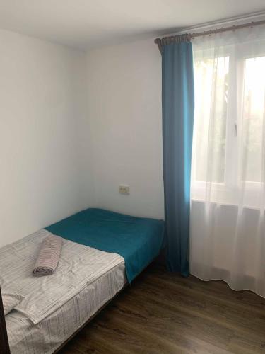 a small bedroom with a bed and a window at AIA Apartment in Kutaisi