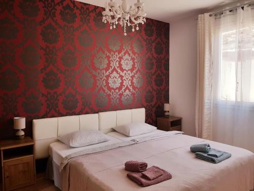 a bedroom with a large bed with red wallpaper at Lina Mogan in Puerto de Mog&aacute;n