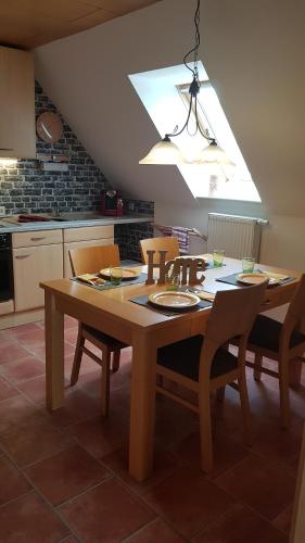 a kitchen with a wooden table with chairs and a light at Kansteinblick Weserbergland in Salzhemmendorf
