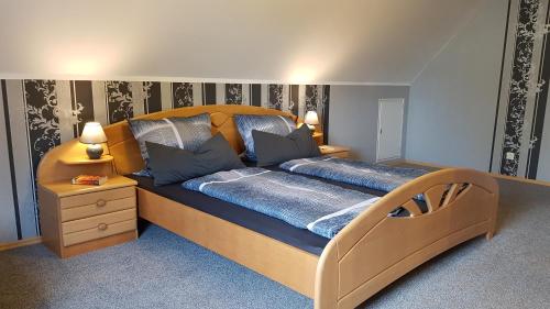 - une chambre avec un grand lit et une tête de lit en bois dans l'établissement Kansteinblick Weserbergland, à Salzhemmendorf