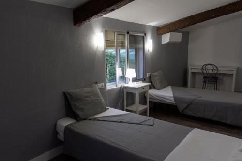una piccola stanza con due letti e una finestra di La Berruca Casa Rural Malpartida de Cáceres a Malpartida de Cáceres